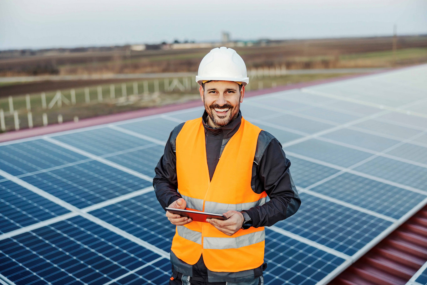 Friendly solar representative with solar panels in the background